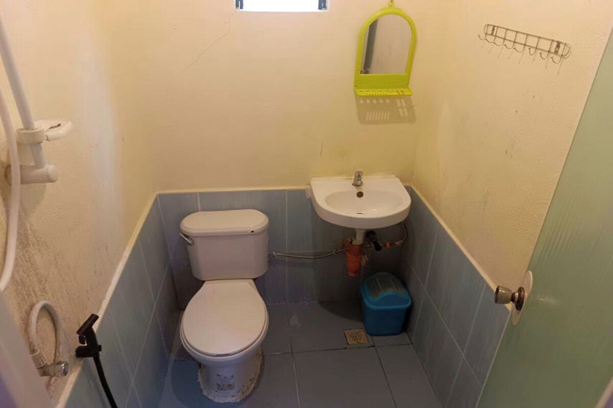 Un bagno piccolo con il water, un lavandino e una finestra sopra il lavandino.