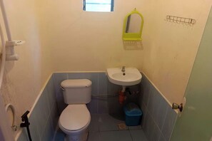 Un bagno piccolo con il water, un lavandino e una finestra sopra il lavandino.