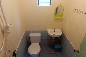 Un bagno piccolo con il water, un lavabo e una finestra sopra il water.