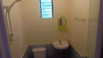 A small bathroom with a toilet, sink, and shower.