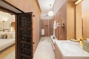 A modern bathroom with a large bathtub, a glass shower enclosure, and a vanity with a gold faucet. - Gulab Haveli - Ihcl Seleqtions, Mandawa (Jhunjhunu)