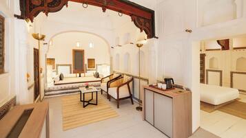 A spacious room with a sofa, a coffee table, and a desk with a lamp.