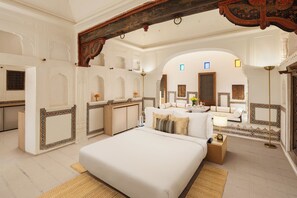 A spacious bedroom with a large bed, a sitting area with a sofa, and a vanity with a mirror. - Gulab Haveli - Ihcl Seleqtions, Mandawa (Jhunjhunu)