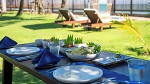 A dining table set outdoors with plates, bowls, and cutlery. - Ceu Ceylon, Tangalle (Kalametiya)