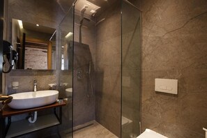 A modern bathroom with a glass-enclosed shower, a freestanding sink, and a marble-tiled wall. - Furra Hotel (Gjirokastër)