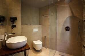 A modern bathroom with a large white sink, a toilet, and a glass-enclosed shower area. - Furra Hotel (Gjirokastër)