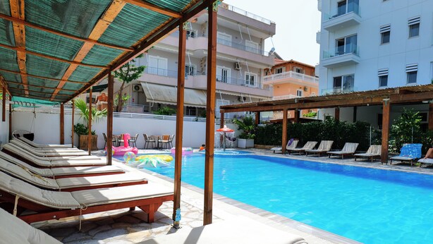 A poolside area with lounge chairs and a covered seating area.