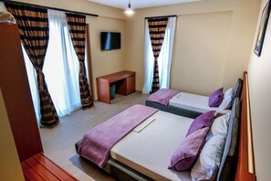A hotel room with two beds, a desk, and a TV. - 6 Miles Hotel (Ksamil)