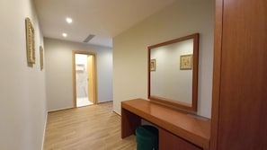 A hallway with a wooden bench, a mirror, and a trash bin. - 6 Miles Hotel (Ksamil)