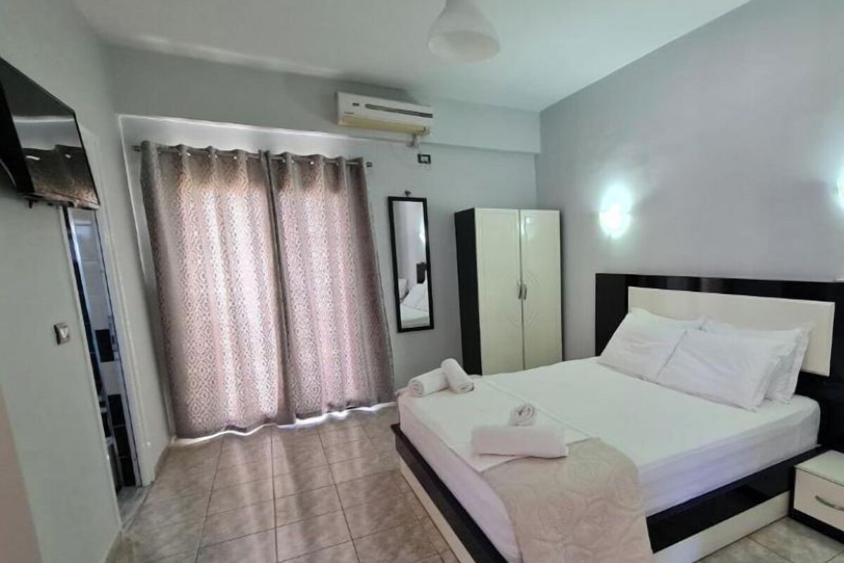 Une chambre à coucher comprenant un lit, une armoire, un miroir et un appareil de climatisation.