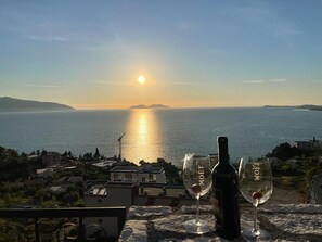 A sunset view from a balcony with a bottle and glasses of wine. - Vila Dena (Vlorë)
