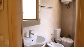 A bathroom with a sink, toilet, and a window. - Danis Hotel (Tirana)