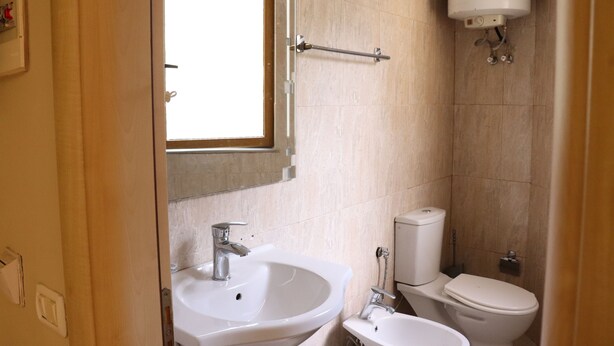 Ein Badezimmer mit Waschbecken, Toilette und Fenster.