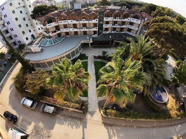 A multi-story hotel with a central courtyard, palm trees, and a swimming pool. - Danis Hotel (Tirana)