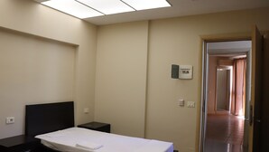 A bedroom with a bed, bedside tables, a ceiling light, and a door leading to another room. - Danis Hotel (Tirana)