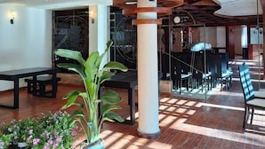 A spacious indoor area with wooden beams, a central column, and a seating arrangement. - Danis Hotel (Tirana)