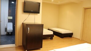 A room with a television mounted on the wall, a wooden cabinet, a bed, and a small bedside table. - Danis Hotel (Tirana)