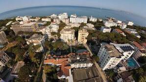 An aerial view of a coastal cityscape with various buildings, including a prominent white structure with a dome, surrounded by smaller residential and commercial buildings. - Danis Hotel (Tirana)