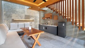 A modern kitchen with a wooden ceiling, built-in cabinets, and a stainless steel refrigerator. - Aqilah Villa Bali (Legian)