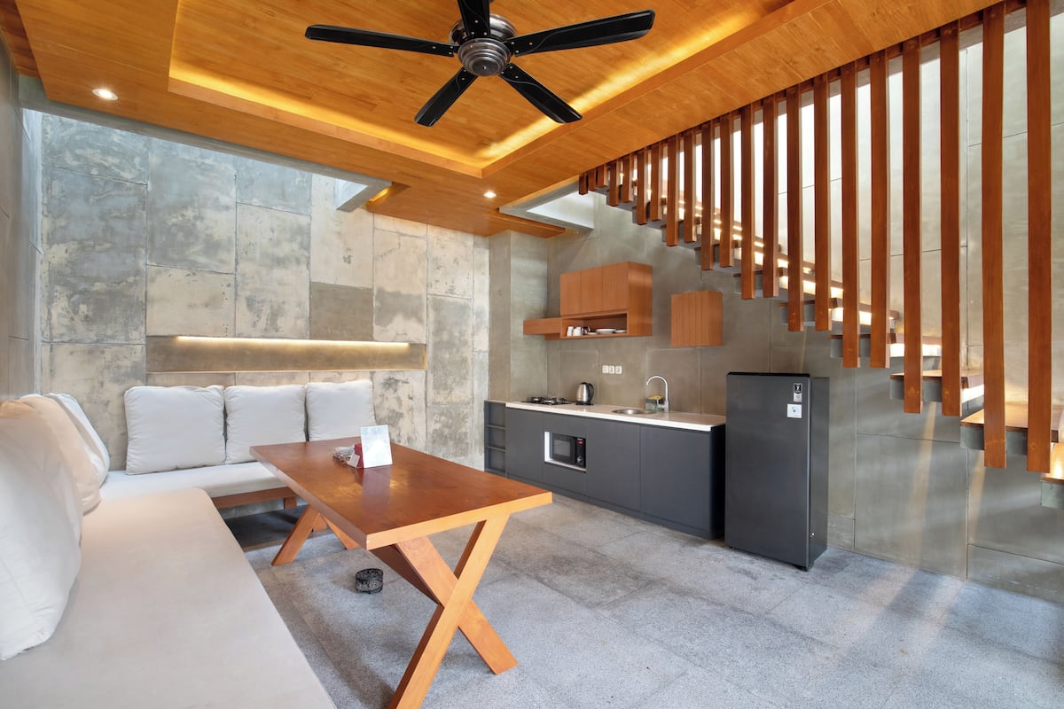 Een moderne keuken met een houten plafond, inbouwmeubels en een roestvrijstalen koelkast.
