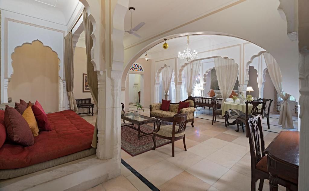 A spacious living area with a sofa, chairs, and a dining table.