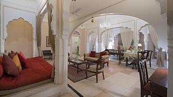 A spacious living area with a sofa, chairs, and a dining table.