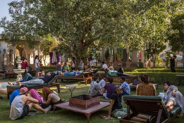 A courtyard with outdoor seating, a fire pit, and a fountain. - Alsisar Mahal- Heritage Palace Hotel (Malasisar)