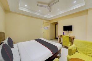 A hotel room with a bed, a desk, a chair, and a television. - Rg Suites Ashok Nagar (Chennai)