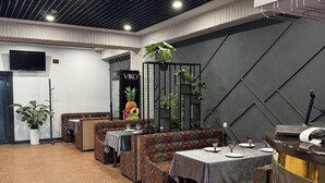 A restaurant with patterned flooring, seating areas, and a counter. - Mehran (Fergana)