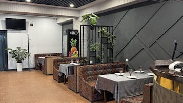 Ein Restaurant mit gemustertem Boden, Sitzbereichen und einer Theke.