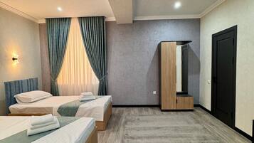 Una habitación de hotel moderna con dos camas, un espejo grande, un armario y piso alfombrado.