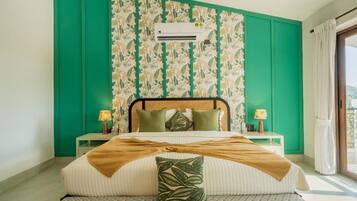 A bedroom with a bed, green walls, an air conditioning unit, and a window with curtains.