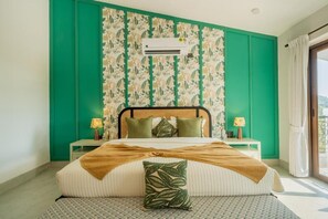 A bedroom with a bed, green walls, an air conditioning unit, and a window with curtains. - Elivaas Paraíso - Villa Goa (Siolim)