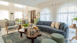 Una sala de estar con sofá, sillas, una mesa de centro y un comedor con mesa y sillas.