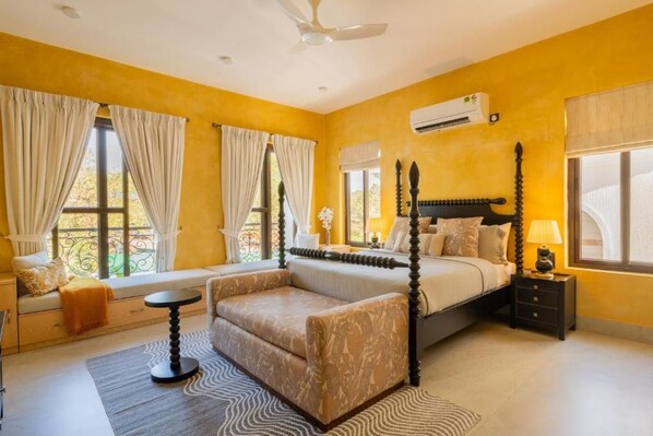 A four-poster bed, a sofa, a small table, and a window with curtains. - Elivaas Paraíso - Villa Goa (Siolim)