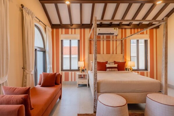 A bedroom with a bunk bed, a sofa, a bedside table with lamps, and a window with curtains. - Elivaas Paraíso - Villa Goa (Siolim)