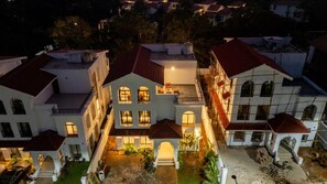 A multi-story residential building with a central courtyard, balconies, and a well-lit entrance. - Elivaas Paraíso - Villa Goa (Siolim)