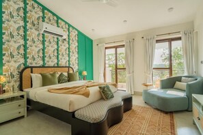 A bedroom with a bed, bedside tables, a chair, and a window with curtains. - Elivaas Paraíso - Villa Goa (Siolim)