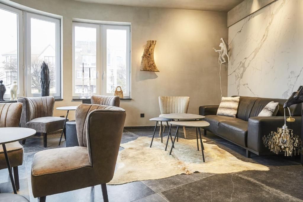 Uma sala de estar moderna com sofás de couro, uma mesa de centro redonda e uma grande janela com vista para a cidade.