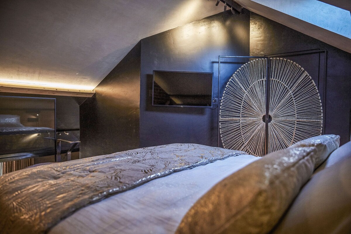 A bedroom with a bunk bed, a circular wall decoration, and a small shelf.