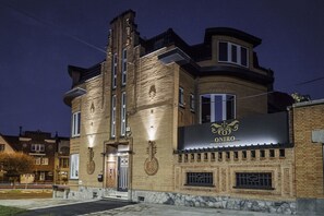 A building with a sign that reads "ONIRO WELLNESS ROOMS & SUITES" at night. - Hôtel Oniro Tournai - Luxury Rooms & Wellnss Suits (Tournai)