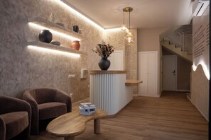 Un intérieur moderne comprenant un comptoir d’accueil, un espace détente et un escalier.