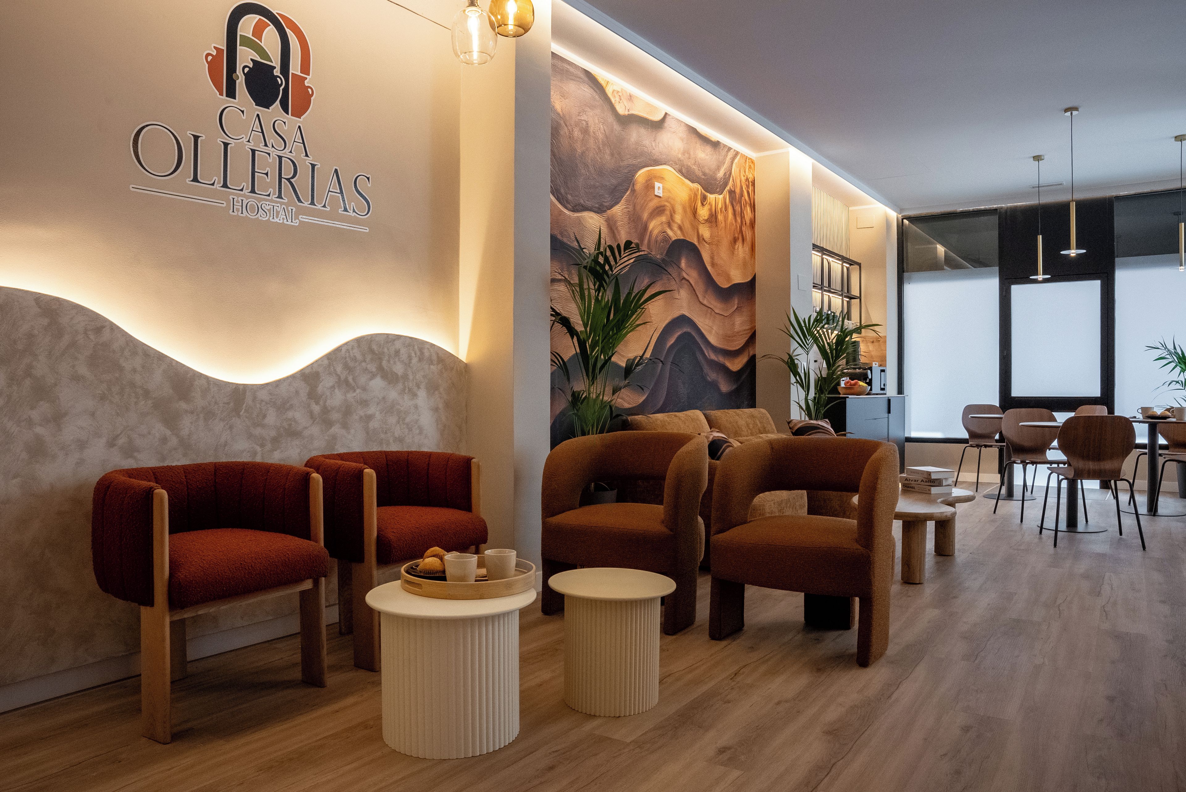 A modern interior with a reception area featuring a logo, comfortable seating, and a decorative wall mural.