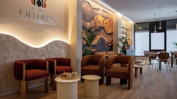 A modern interior with a reception area featuring a logo, comfortable seating, and a decorative wall mural.