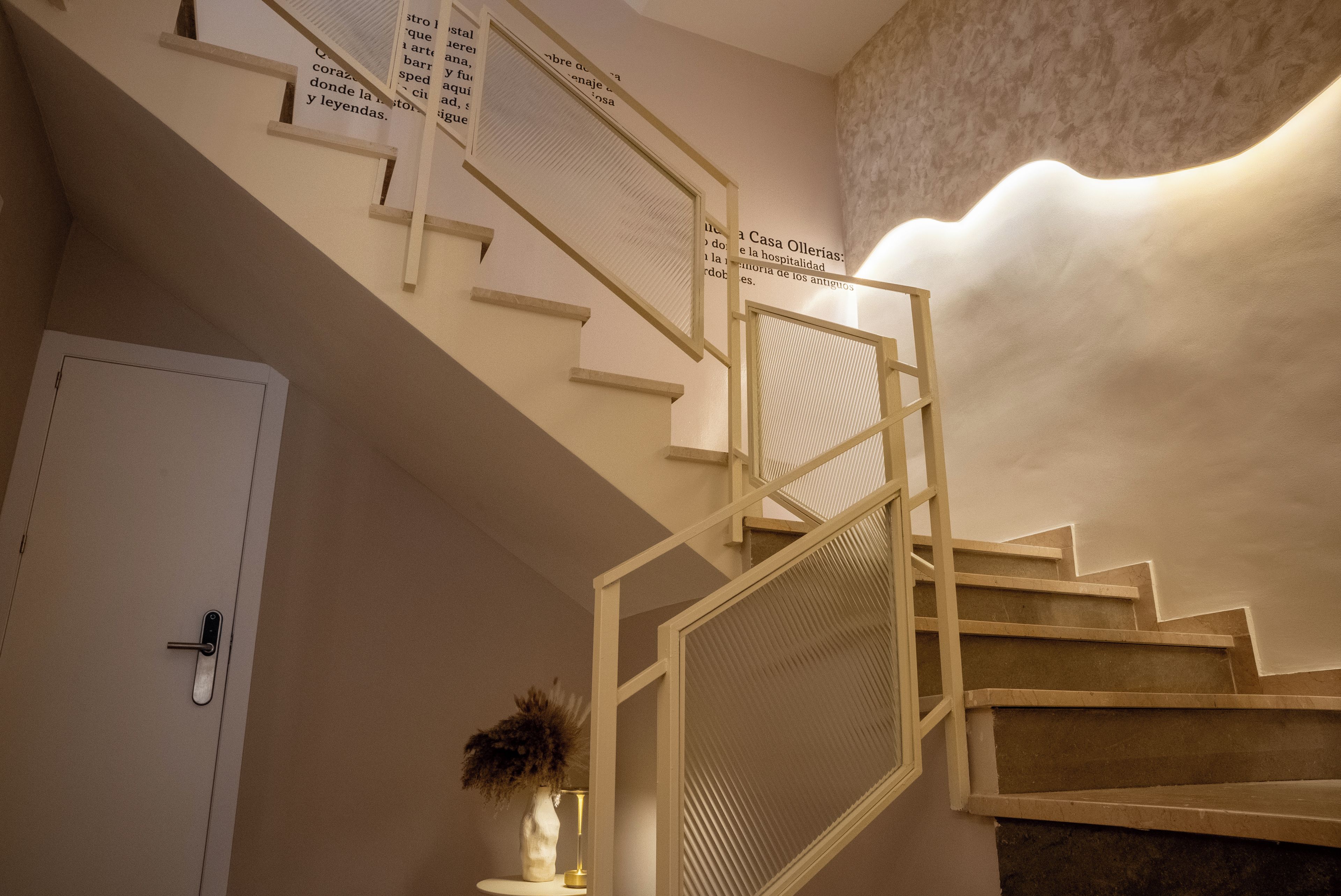 A staircase with a handrail, a door, and a wall with a textured pattern.