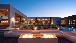 A modern outdoor pool area with built-in seating and a fire feature. - Koia All-suite Wellbeing Resort (Kos)
