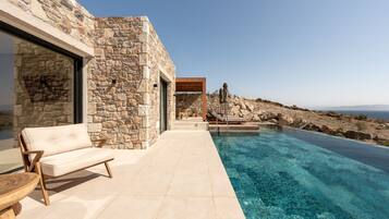 A stone building with a pool, a sofa, and a table.