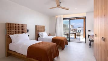 A hotel room with two beds, a ceiling fan, a large window with a view, and a wooden wardrobe.
