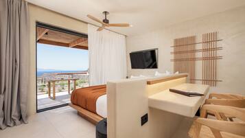 A modern hotel room with a bed, a desk, a TV, and a balcony with a view.