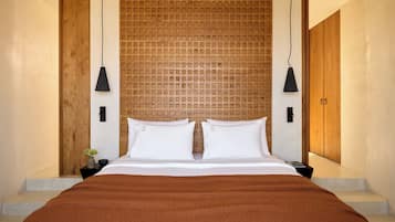 Ein modernes Schlafzimmer mit einem großen Bett, einem Holzkopfbrett und zwei Pendelleuchten.